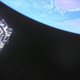 Webb is a glittering silver cube against the darkness of space, with bright blue Earth filling the top of the image.